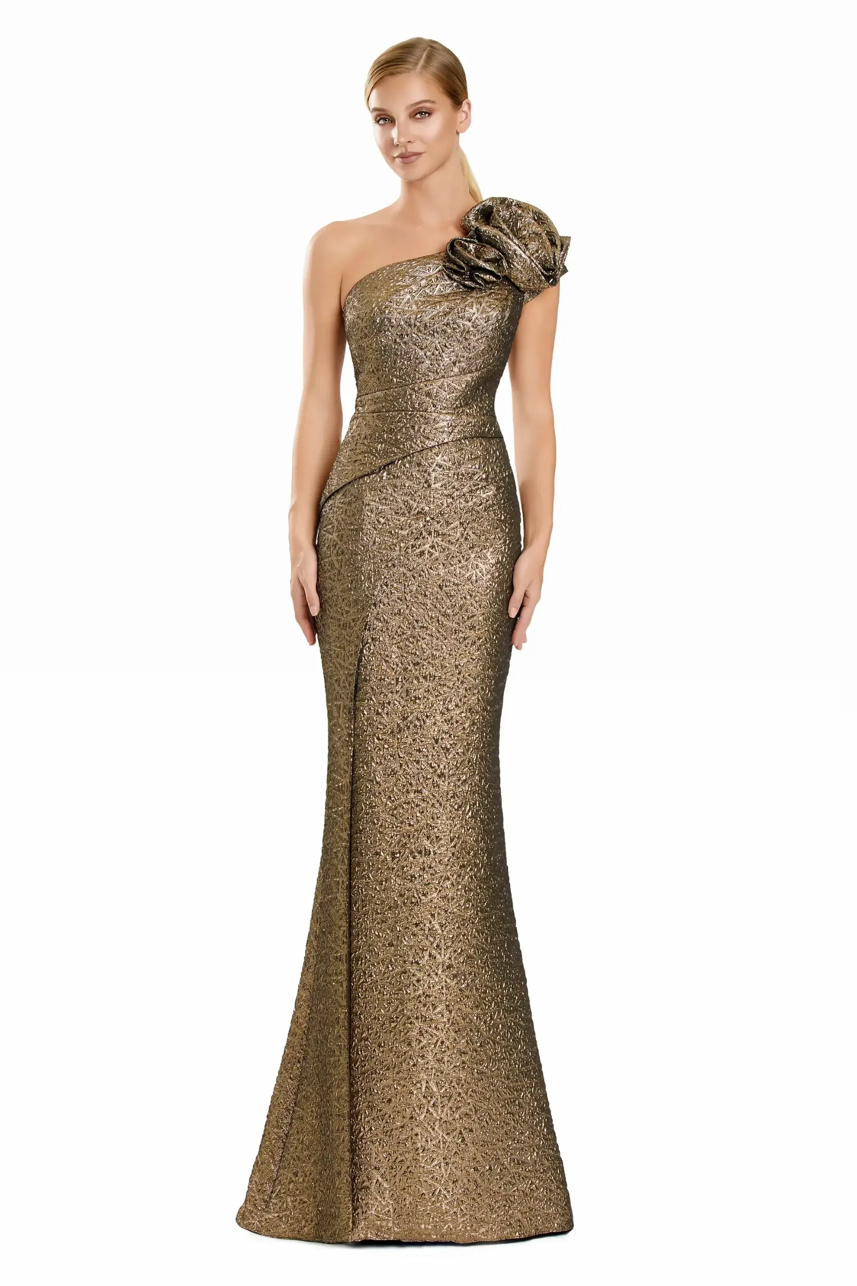 A woman in a shimmering one-shoulder, gold evening gown with an ornate floral accent stands poised against a white background, exuding elegance and confidence.
