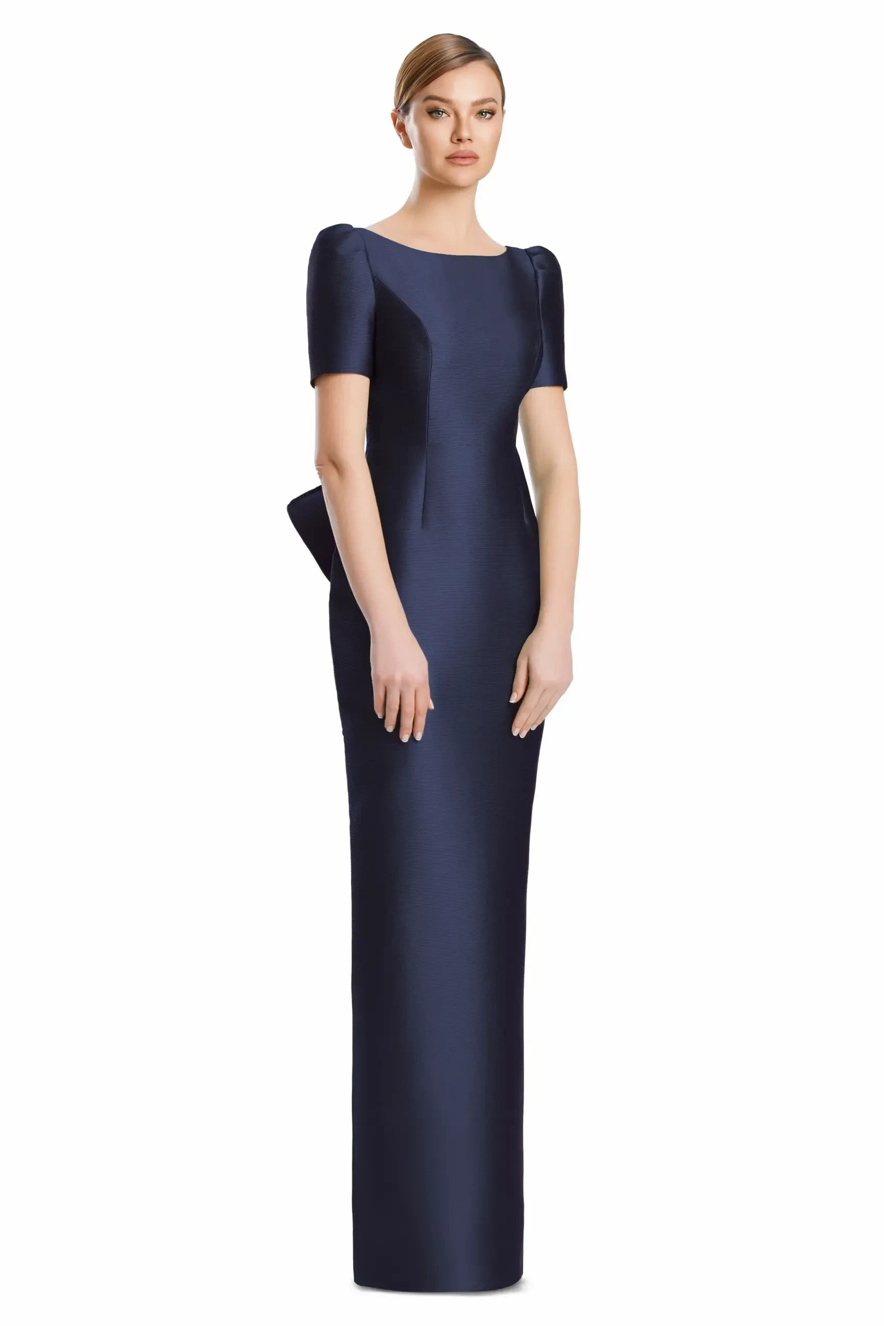 A model wearing a long, fitted navy blue evening gown with short puff sleeves and a peplum detail.