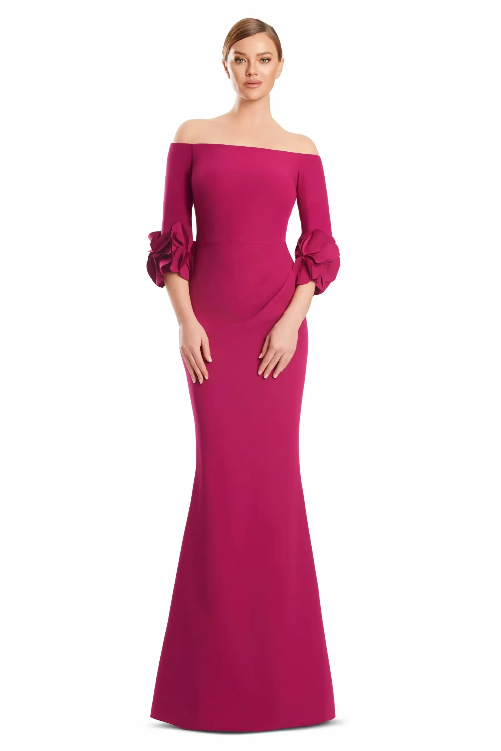 A model wearing a long, fitted, off-the-shoulder pink dress with ruffled sleeves.