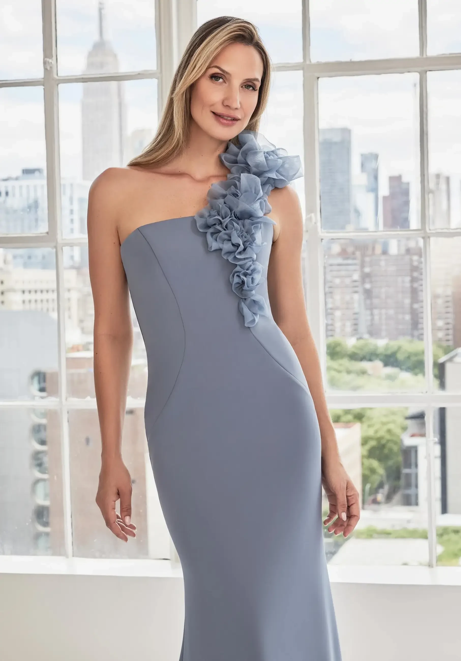 Model is wearing a fit and flare mother of the bride dress with a one shoulder strap